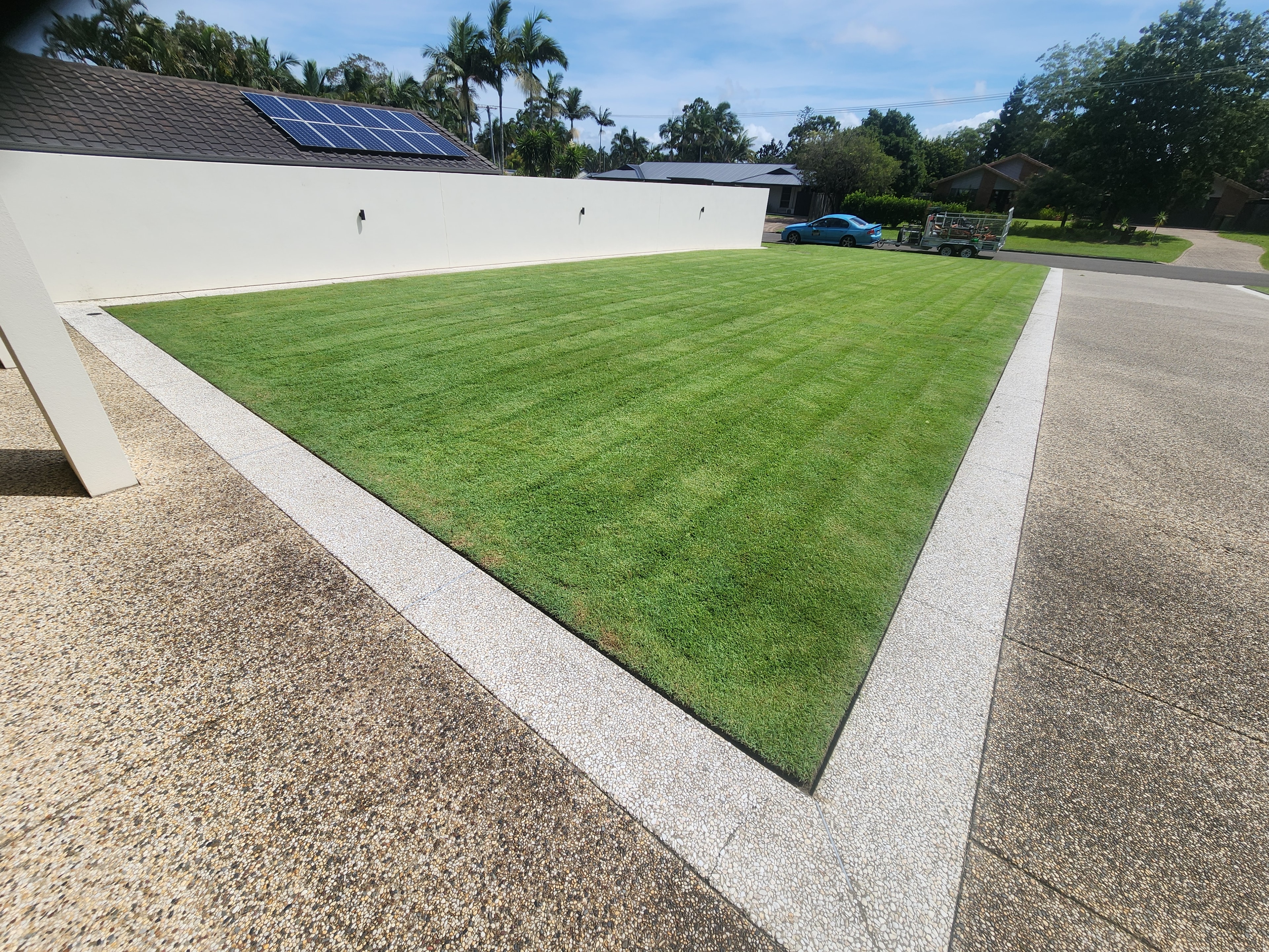 Modern home with striped manicured lawn